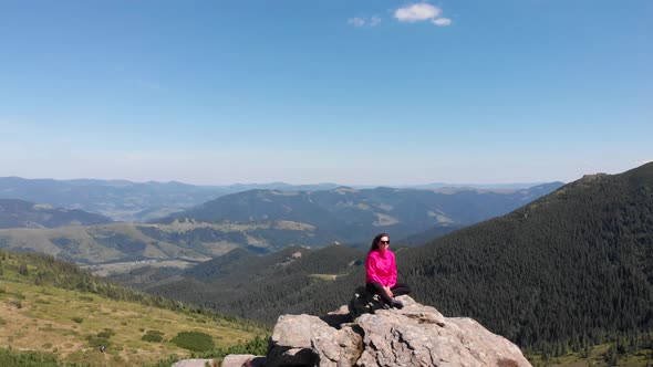 Meditation and Relaxation in the Mountains. Girl on a Mountain Peak. Unity with Nature. Mountains