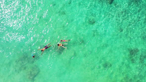 Young people swim on green turquoise calm shallow lagoon, watching beautiful rocks, corals and tropi alt