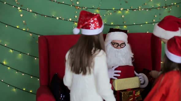 Santa Claus gives presents to small children. Christmas holiday alt