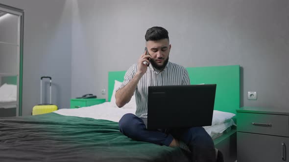 Portrait of Handsome Successful Overworking Man Talking on the Phone Hanging Up Sitting on Bed with alt