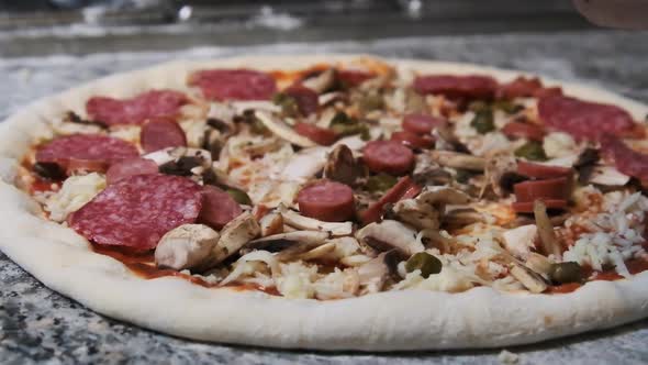 Chef Hand Deliciously Puts Sliced Salami Sausage on the Pizza. Slow Motion alt