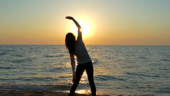 Girl Doing Morning Exercise By the Sea at Dawn