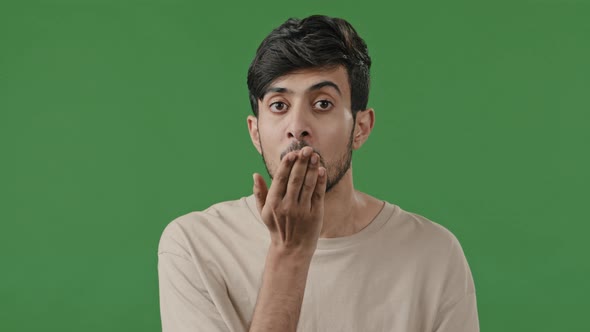 Lovely Romantic Brunette Handsome Arabian Man Looking at Camera Blowing Air Kiss Over Male Hand alt