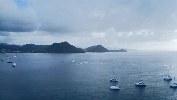 Aerial footage of water bike circling among yachts in the sea (Rodney Bay, Saint Lucia) alt