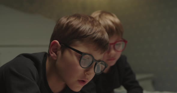 Siblings in Eye Glasses Reading Paper Book alt