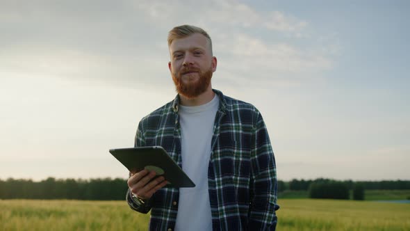 Portrait of a Successful Male Farmer with a Tablet in the Field alt