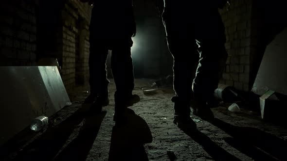 Group of Armed Men in Camouflage Carefully Approach in Corridor in Light alt