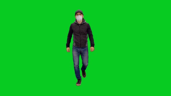 Man In Mask And Casual Clothing Walking During Pandemic COVID-19 on Green Screen
