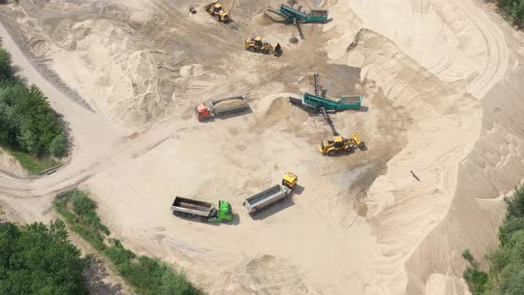 Aerial view of mining machinery working at sand quarry. Mining equipment alt