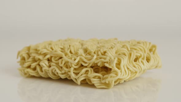 Uncooked Chinese  noodles on white background 4K 2160p 30fps UltraHD tilting footage - Instant stapl