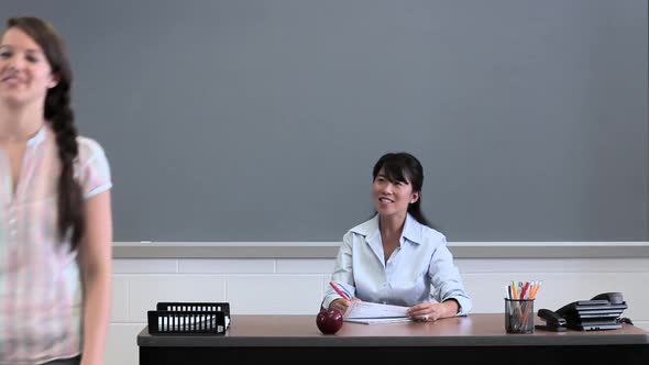 High school students giving teacher apples and fruit basket alt