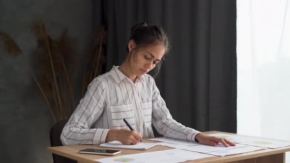 Focused Girl Writing Notes Working with Chart and Documents Study with Papers and Books Serious alt