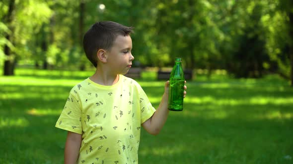 Boy drinking water from a bottle in the park alt