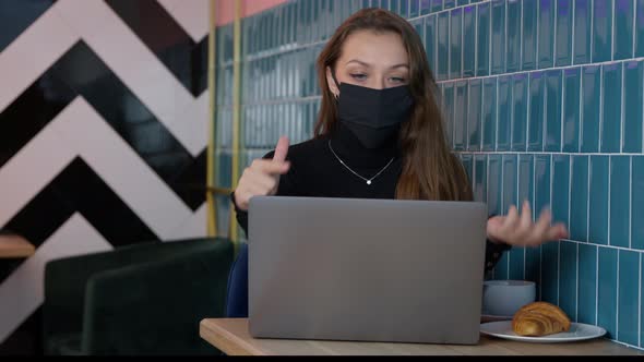 Attractive Longhaired Girl in Black Protective Mask Messaging Chatting in Cafe