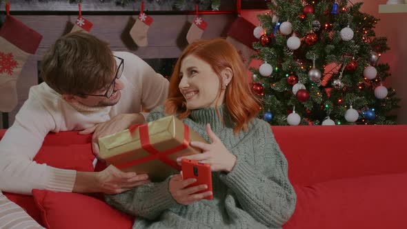 Emotional positive caucasian couple enjoying New Year. Christmas presents. alt