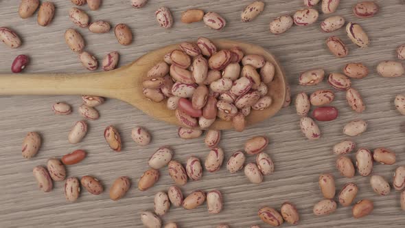 Red borlotti beans legumes on wooden spoon, Mediterranean diet healthy nutrition alt
