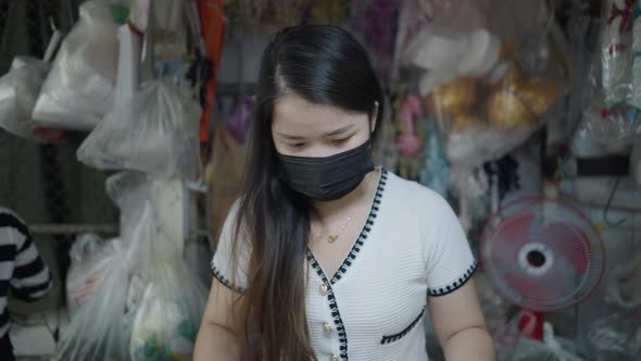 Store Worker In Safety Mask Preparing Flower Products Inside Pak Khlong Talat Bangkok Thailand alt