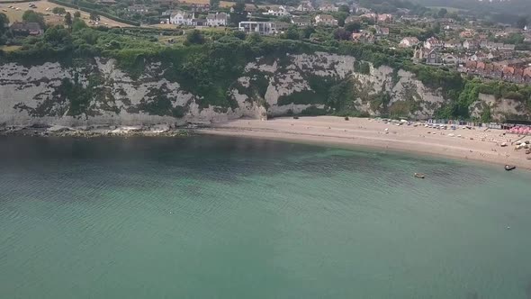 Aerial view showing the beautiful village of Beer in Devon, UK. Descending down towards the ocean. alt