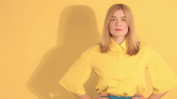 Young Woman in Bright Clothes on Bright Yellow Background in Studio