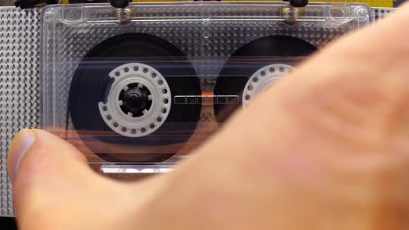 Hand Inserts A Cassette Into The Tape Recorder And Play Music