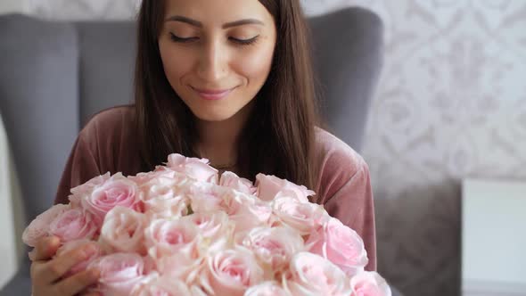 Happy Woman Look on Bouquet of Roses alt