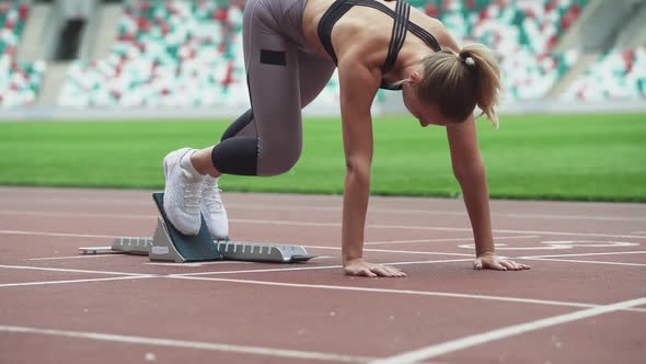Young Female Sprinter is Preparing for the Start of a Training Run
