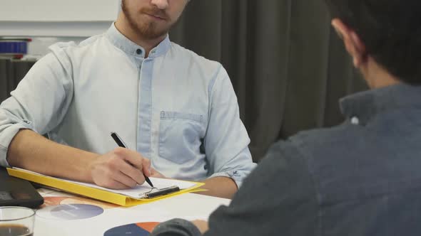 Handsome Businessman Taking Notes During Business Meeting alt