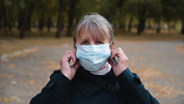 Senior Woman Takes Off Medical Mask