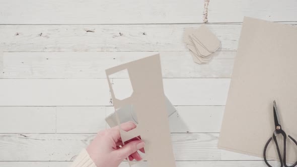 Flat lay. Step by step. Cutting out gift tags from brown paper with a paper punch. alt