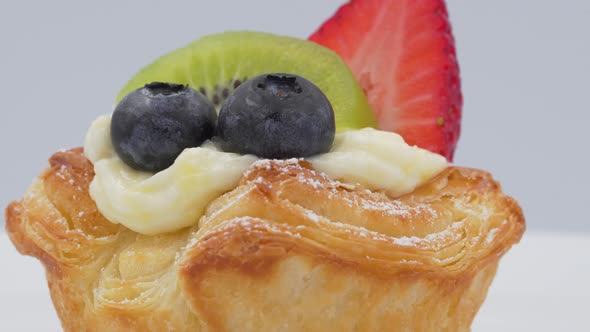 Rotates view of fresh croissant mix fruits with whipped cream and strawberries blueberries
