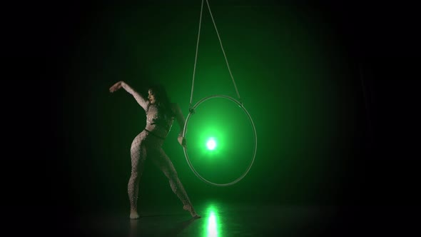 Aerial Acrobat in the Ring. A Young Girl Performs the Acrobatic Elements in the Air Ring on Green alt
