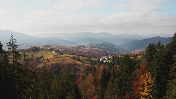 Mountain Valley with Houses and Forests at Sunrise alt
