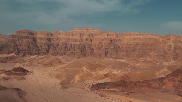 Slow backwards moving shot of a beautiful big desert canyon filmed with a drone, great for transitio alt