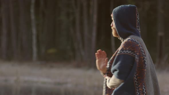 ZOOM IN - An ice bathing handsome bearded man warming up doing qigong tai chi alt