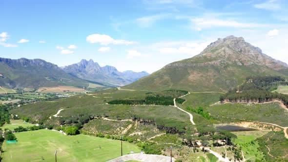 Aerial drone, Stellenbosch university outdoor sports complex and stadium, mountain slope, green fiel alt