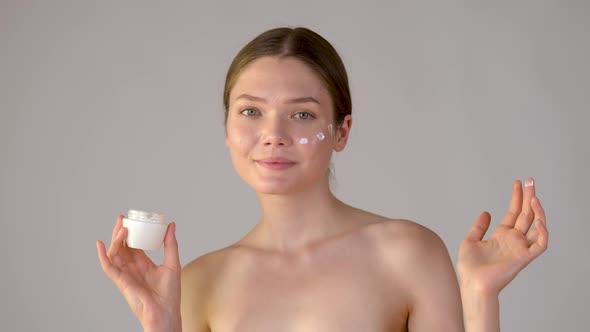 beauty and skincare. portrait attractive smiling woman holding skin care cream alt