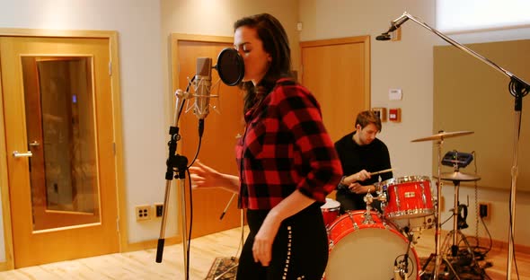 Woman singing in recording studio alt