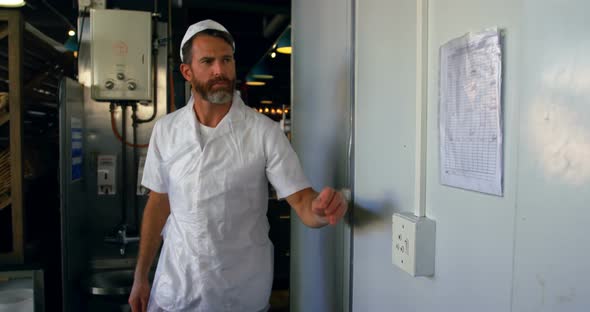 Chef examining sheet hung on the wall 4k alt