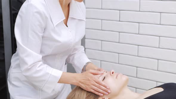 Cosmetologist Does Woman Facial Massage with Her Hands Relaxation and Pleasure Skin Correction