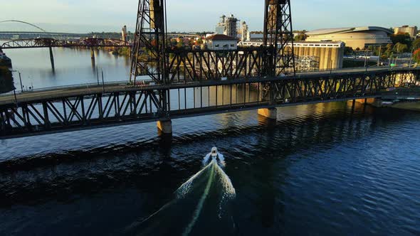 Beautiful Aerial View of Boat on Willamette River Going Under a Bridge alt