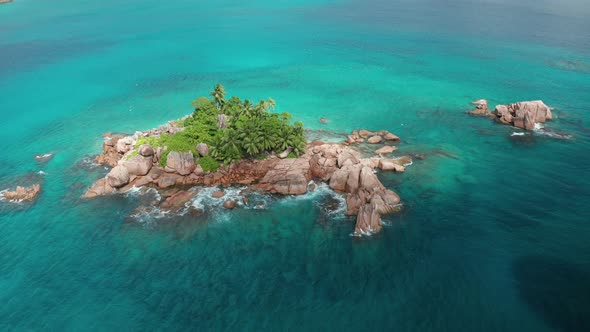 Aerial arc shot around granite uninhabited tiny islet Saint Pierre alt