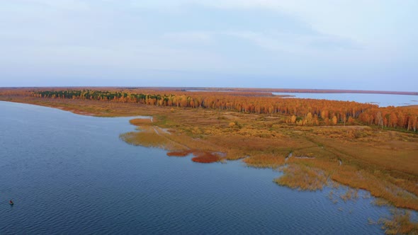 Aerial Top View of Beautiful Lake Surrounded By Colorful Forest in Autumn