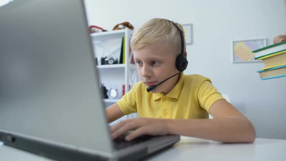 Mother Putting Books on Desk, Son in Headset Playing Game on Laptop Pc Addiction