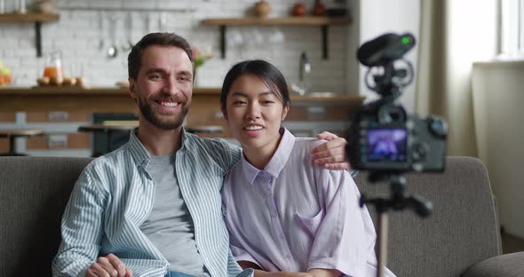 Young Family Bloggers Recording Video for Internet with Professional Video Camera Mounted on Tripod alt