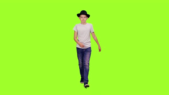 Teen Boy Walking in White T-shirt and Black Hat