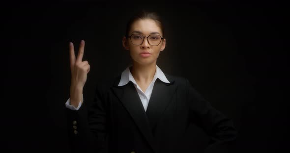 Business Woman with Glasses with a Serious Face Shows Two Finger alt