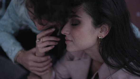 Couple Gently Sitting Outdoors Closeup alt