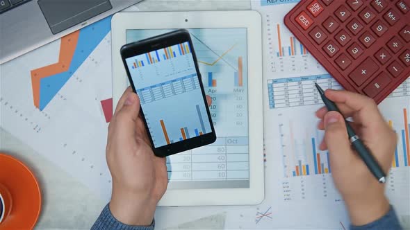 Businessman Analyzing Stock Report On Smart Phone