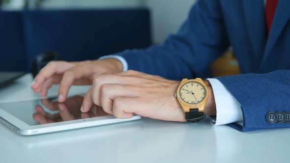 Businessman Hand With Wooden Watch Using Tablet