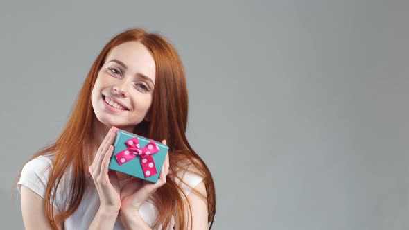 Portrait of Beautiful Smiling Redhead Girl Hold Gift Box in Hands